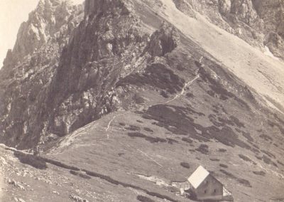 Kočo na Kamniškem sedlu je kamniška podružnica Slovenskega planinskega društva zgradila leta 1906. Fotografija je iz leta 1922.